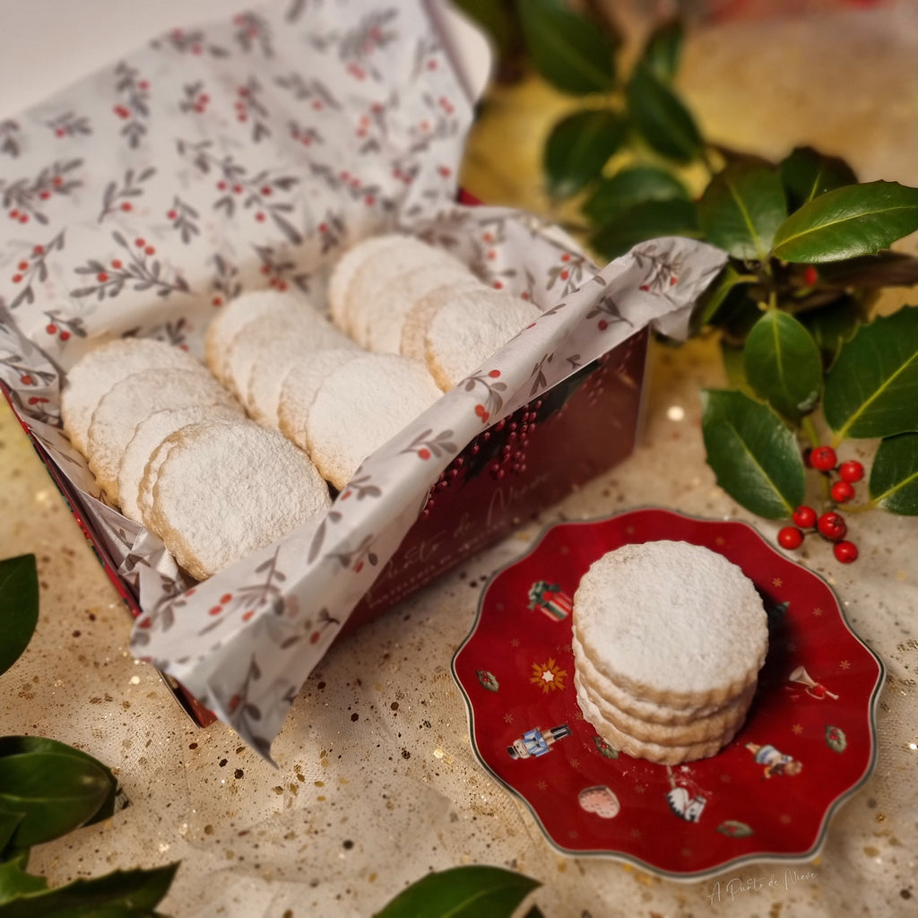 Nevaditos artesanos en caja de cartón ilustrada con acebo