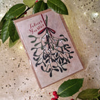 Cannoli artesano de pistacho en caja festiva con ilustración de acebo